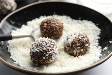 Beyaz masada fındıklı ve hindistan cevizli lezzetli çikolatalar yapmak, yakın plan.