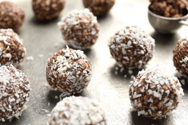 Gri masada fındıklı ve hindistan cevizli lezzetli çikolatalar, yakın plan.