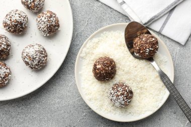 Gri masada hindistan cevizi taneleriyle lezzetli çikolata şekerlemeleri yapmak.