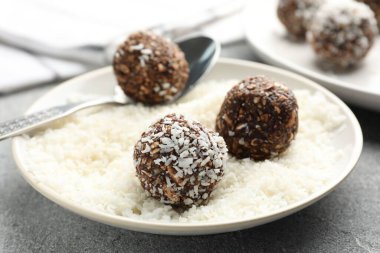 Gri masada hindistan cevizi gevreğiyle lezzetli çikolatalar yapmak, yakın plan.