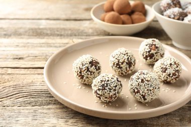 Tahta masada fındık ve susam tohumlu lezzetli çikolatalar, yakın plan.