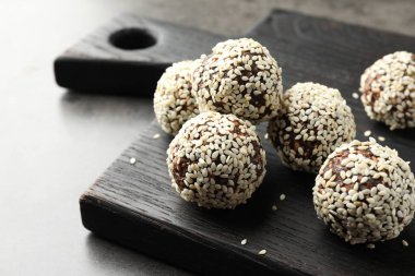 Gri masada fındıklı ve susamlı çikolatalı şekerler, yakın plan.