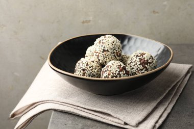 Gri masada fındıklı ve susamlı çikolatalı şekerler, yakın plan.