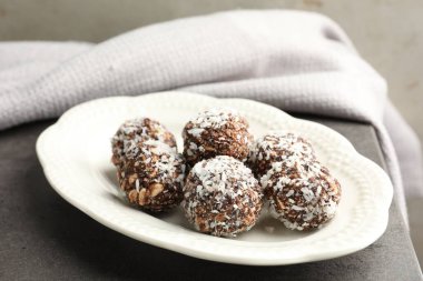 Gri masada fındıklı ve hindistan cevizli lezzetli çikolatalar, yakın plan.