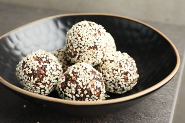 Gri masada fındıklı ve susamlı çikolatalı şekerler, yakın plan.