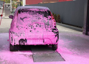 Dışarıdaki oto yıkamada temizleme köpüğüyle kaplanmış.