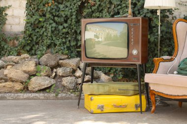 Retro TV stantta, bavullar ve diğer kullanılmış eşyalar dışarıda.