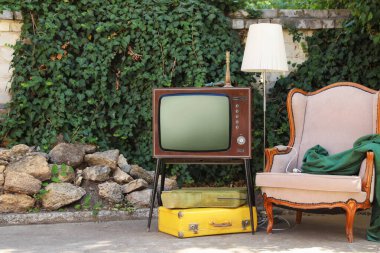 Retro TV stantta, koltuk ve diğer kullanılmış eşyalar dışarıda.