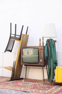 Tribünde Retro TV ve dışarıdaki beyaz duvarın yanında kullanılan diğer şeyler.