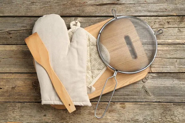 Fırın eldiveni ve diğer mutfak gereçleri ahşap masada, düz yatıyordu.