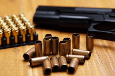 Mermiler ve silah ahşap masada, yakın plan.