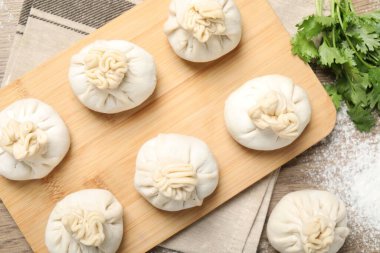 Tahta masada pişmemiş khinkalis (hamur tatlısı) ve kişniş, düz konum