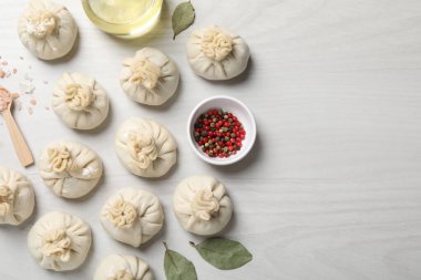 Pişmemiş khinkaliler (hamur tatlısı) ve beyaz ahşap masa üzerindeki baharatlar, düz yatış. Metin için boşluk
