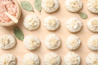 Pişmemiş khinkaliler (hamur tatlısı) ve ahşap masa üzerindeki baharatlar, düz konum