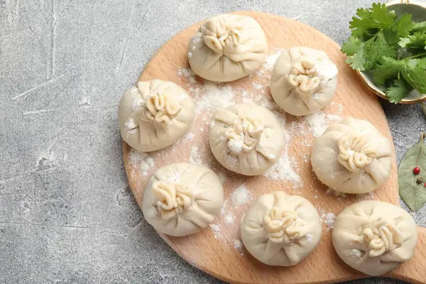 Pişmemiş khinkaliler (hamur köfteleri) gri masada, düz yerde. Metin için boşluk