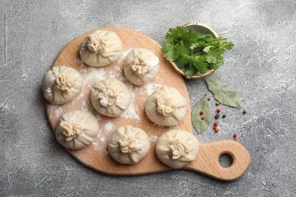 Biber, un, maydanoz ve körfez yapraklarıyla pişirilmemiş khinkaliler (hamur köfteleri) gri masada, düz yatıyordu.