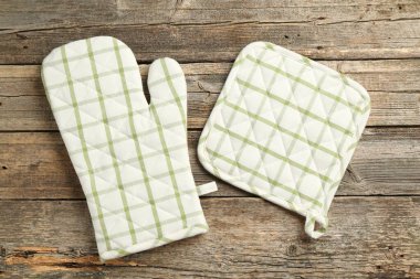 Fırın eldiveni ve tutacağı ahşap masada, düz yatıyordu.