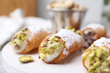 Ricotta peynirli, fıstıklı ve pudra şekerli nefis cannoli. Arka planda bulanıklık var. Yakın plan.