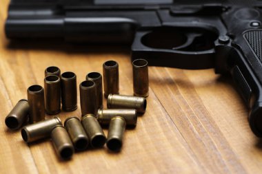 Mermiler ve silah ahşap masada, yakın plan.