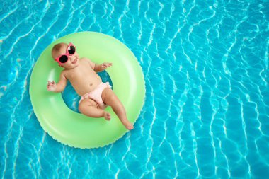 Yüzme havuzunda şişirilebilir yüzüklü şirin bir bebek. Metin için boşluk