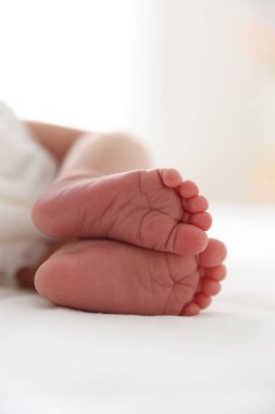 Sevimli yeni doğmuş bebek yatakta uzanıyor, yakın plan.