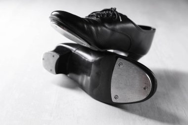 Beyaz tahta zeminde step dansı için bir çift ayakkabı, yakın plan.