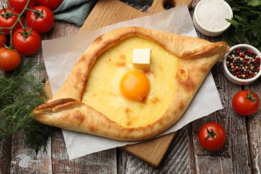 Lezzetli khachapuri peyniri, yumurtası ve diğer ürünleri ahşap masada, düz yatıyordu.