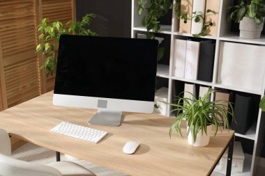 Ofisinde modern bilgisayar ve çiçek dekoru olan şık bir iş yeri. Biyofilik iç tasarım