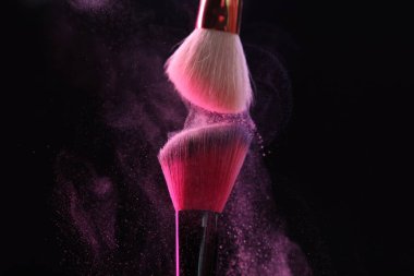 Siyah arka planda pembe göz farlı makyaj fırçaları, yakın plan