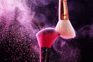 Renkli göz gölgeli makyaj fırçaları siyah arka planda neon ışıkları, yakın plan