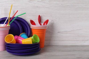 Açık gri ahşap masada tek kullanımlık plastik sofra takımı. Metin için boşluk