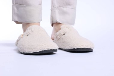 Beyaz arka planda yumuşak terlikli kadın, yakın plan.