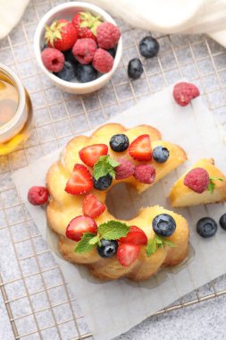 Böğürtlenli, ballı ve nane şekerli leziz kek açık gri masa, düz uzanma