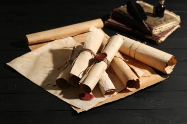 Birçok eski tomarlar ve kitaplar siyah ahşap masa üzerinde, yakın plan