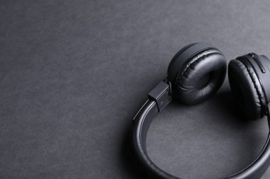Siyah arka planda bir çift şık kulaklık, yakın plan. Metin için boşluk