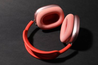 Siyah arka planda bir çift şık pembe kulaklık.