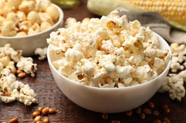 Tahta masada lezzetli patlamış mısır ve mısır taneleri, yakın plan.