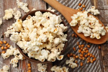 Tahta masada patlamış mısır ve mısır taneleri var.