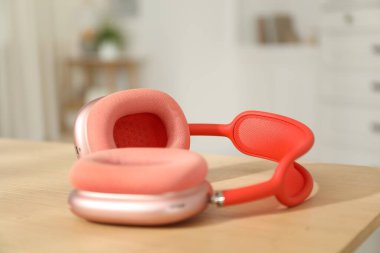 Modern kablosuz kulaklıklar ahşap masa içinde, yakın plan.