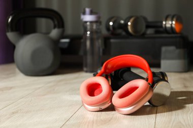 Spor salonunda kablosuz kulaklık ve dambıllar. Metin için boşluk