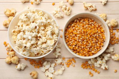 Lezzetli patlamış mısır ve mısır taneleri beyaz ahşap masada, düz yatıyordu.