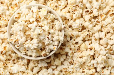 Arka plan olarak lezzetli patlamış mısır ve kase, yakın plan.