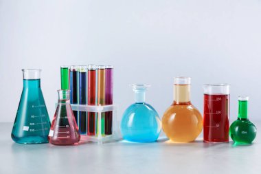 Işık arka planında renk sıvıları olan farklı laboratuvar camları.