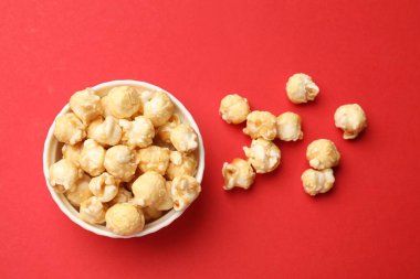 Kırmızı arka planda kasede lezzetli patlamış mısır.