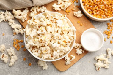 Açık gri masada patlamış mısır ve mısır taneleri, düz uzanmış