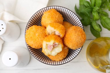 Lezzetli kızarmış köfteler kasede ve baharatlar beyaz ahşap masada, düz yerde.