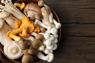 Tahta masadaki kasede farklı çiğ mantarlar, üst manzara. Metin için boşluk