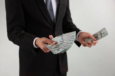 Arka planda dolar banknotları olan adam, yakın plan.