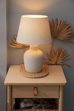 Şık ahşap sehpa. Lambanın yanında ışık duvarı var.