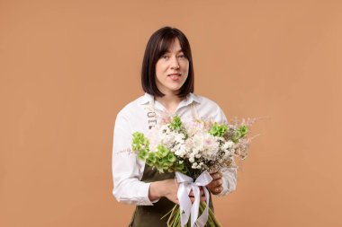 Bej arka planda güzel bir buket çiçekli çiçekçi.